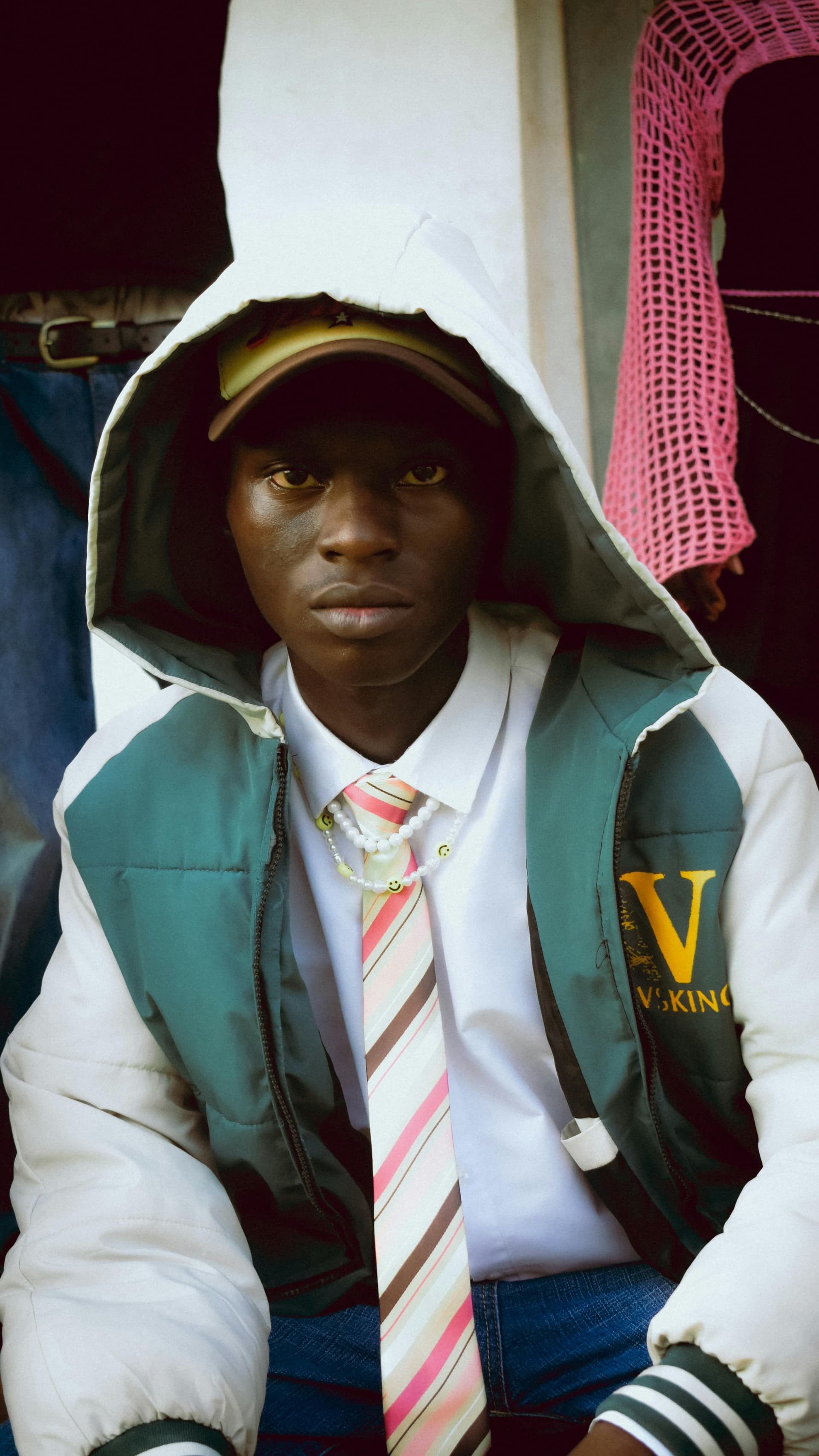 A saved look: a hooded varsity puffer over a white shirt and striped tie